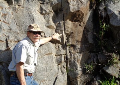 adult male pointing to rock formation