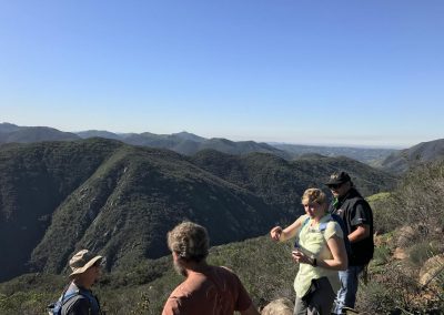 4 hikers with mountains in the background