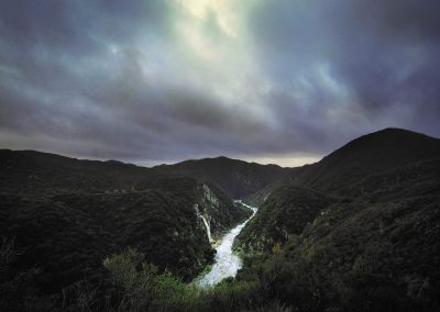 overlook view of river with waterfall and cloudy sky