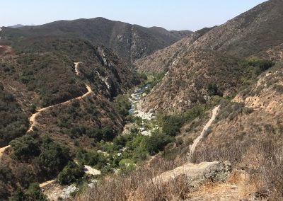A river runs at the bottom of a steep canyon